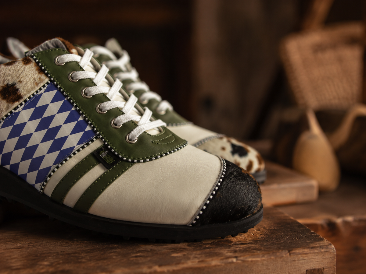 Raubirl Lederschuhe in Grün, Creme und Blau mit Rautenmuster und Fell-Details im rustikalen Werkstatt-Ambiente